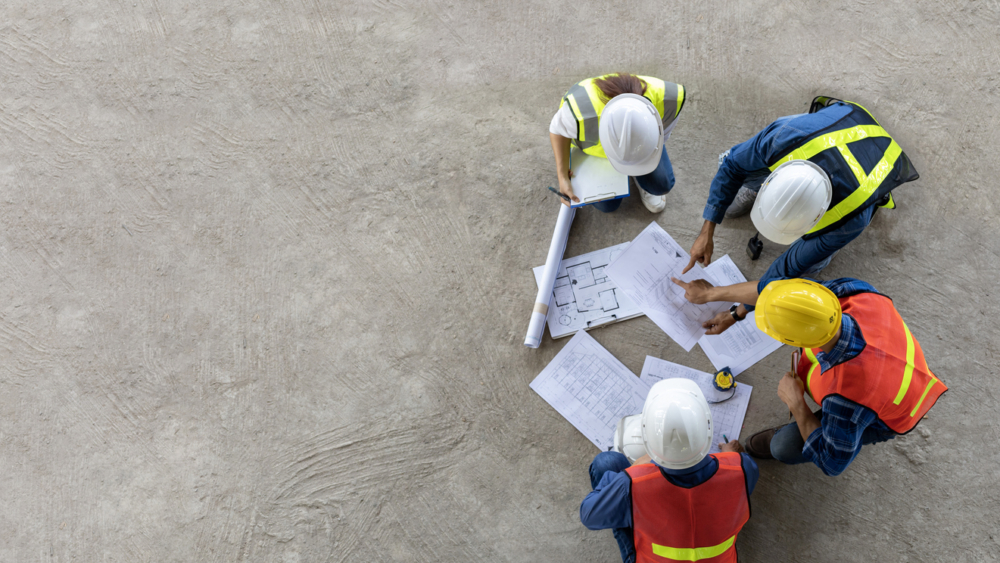Top view of engineer, architect, contractor and foreman meeting at the construction building site with floor plan for real estate development project industry and housing timeline usage