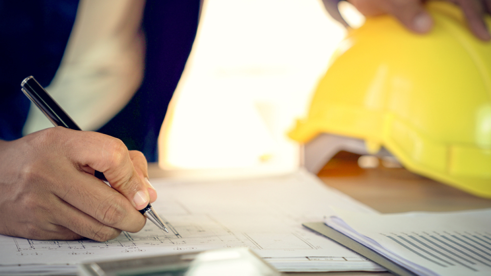 Engineer and architect working document about progress of work schedule and construction drawing on the site