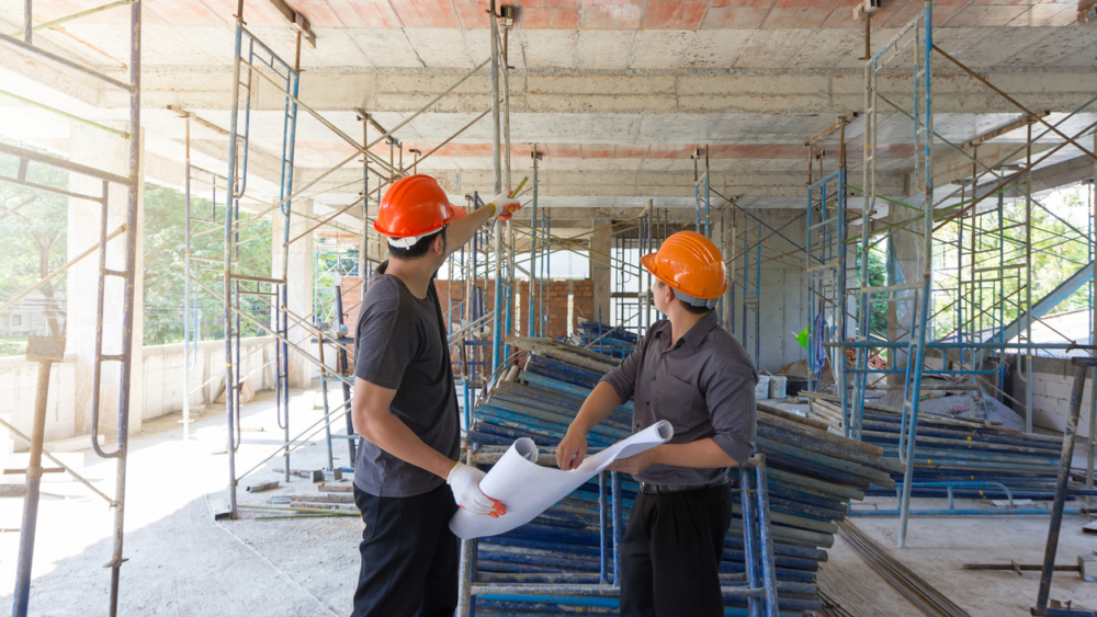Construction concepts, Engineer and Architect working at Construction Site with blueprint